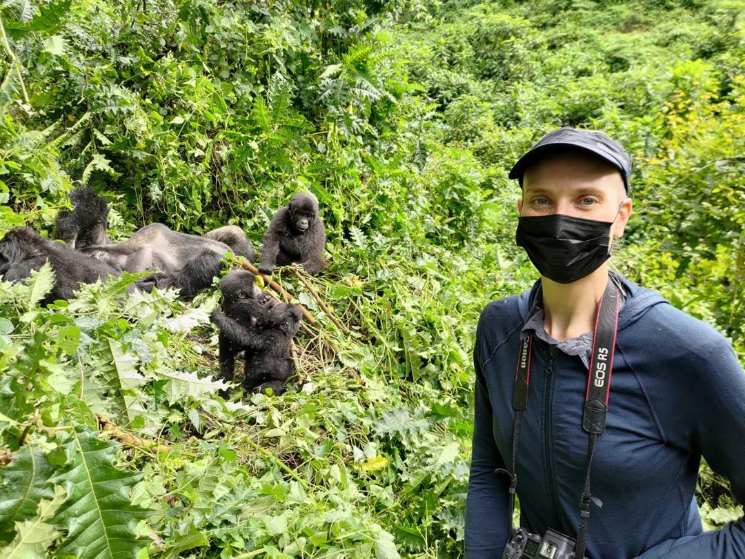 Vibrant Holiday Safaris Client enjoying a 14 days Ultimate Uganda Safari Adventure with Mountain Gorillas at the background