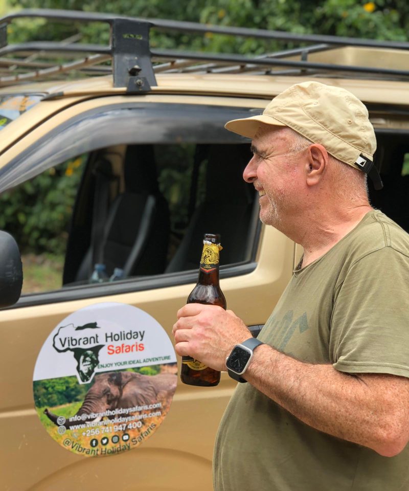 Vibrant Holiday Safaris Sipping a bottle of beer on a 7 Days Wildlife and Primates Safari after a successful Gorilla trek